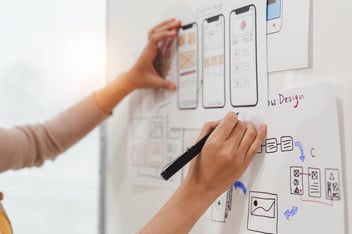 A person drawing wireframes on paper