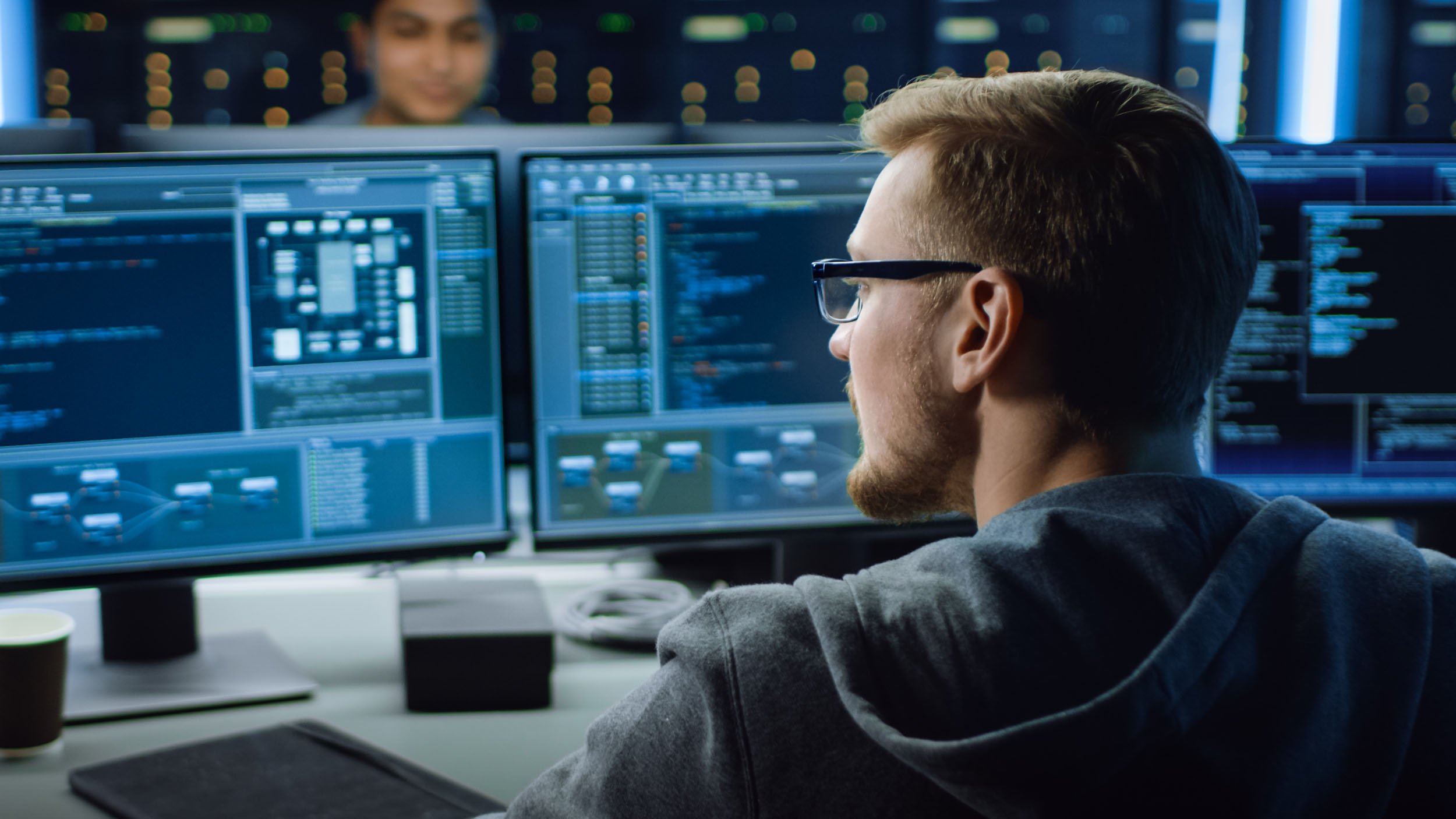 IT specialist working on computer with code