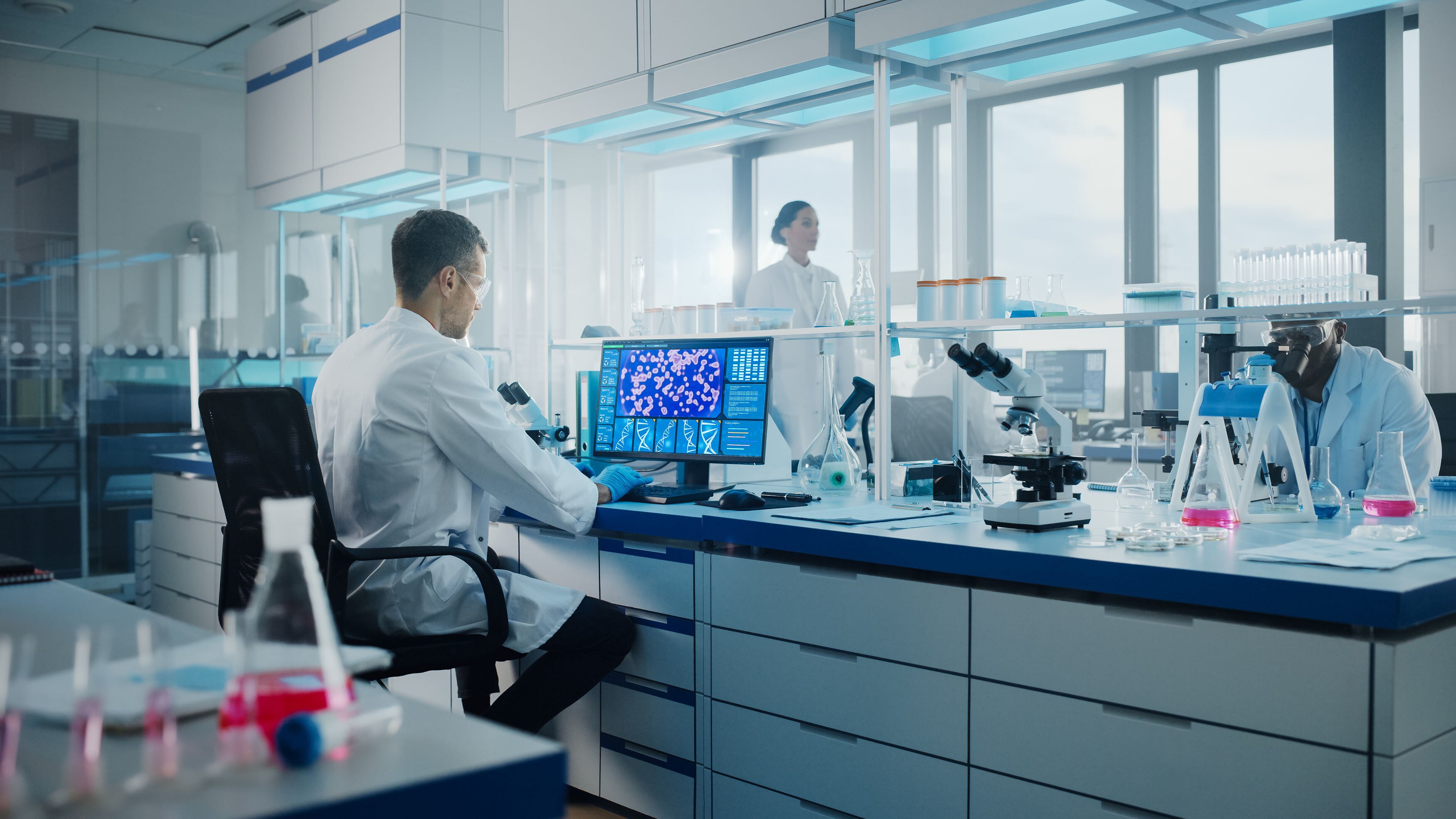 Microbiologist working on computer with display showing gene editing interface