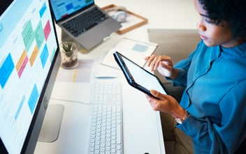 Woman with computer, notebook and schedule in office