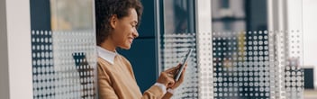 Business woman using phone standing in office