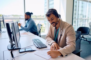 IT agent taking notes while working on computer in office