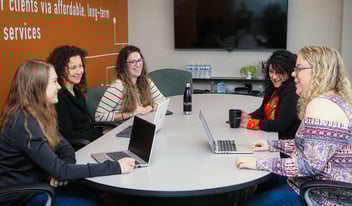 Women gathered with laptops in a conference room