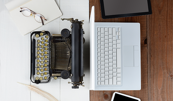 Typewriter and laptop sitting back to back