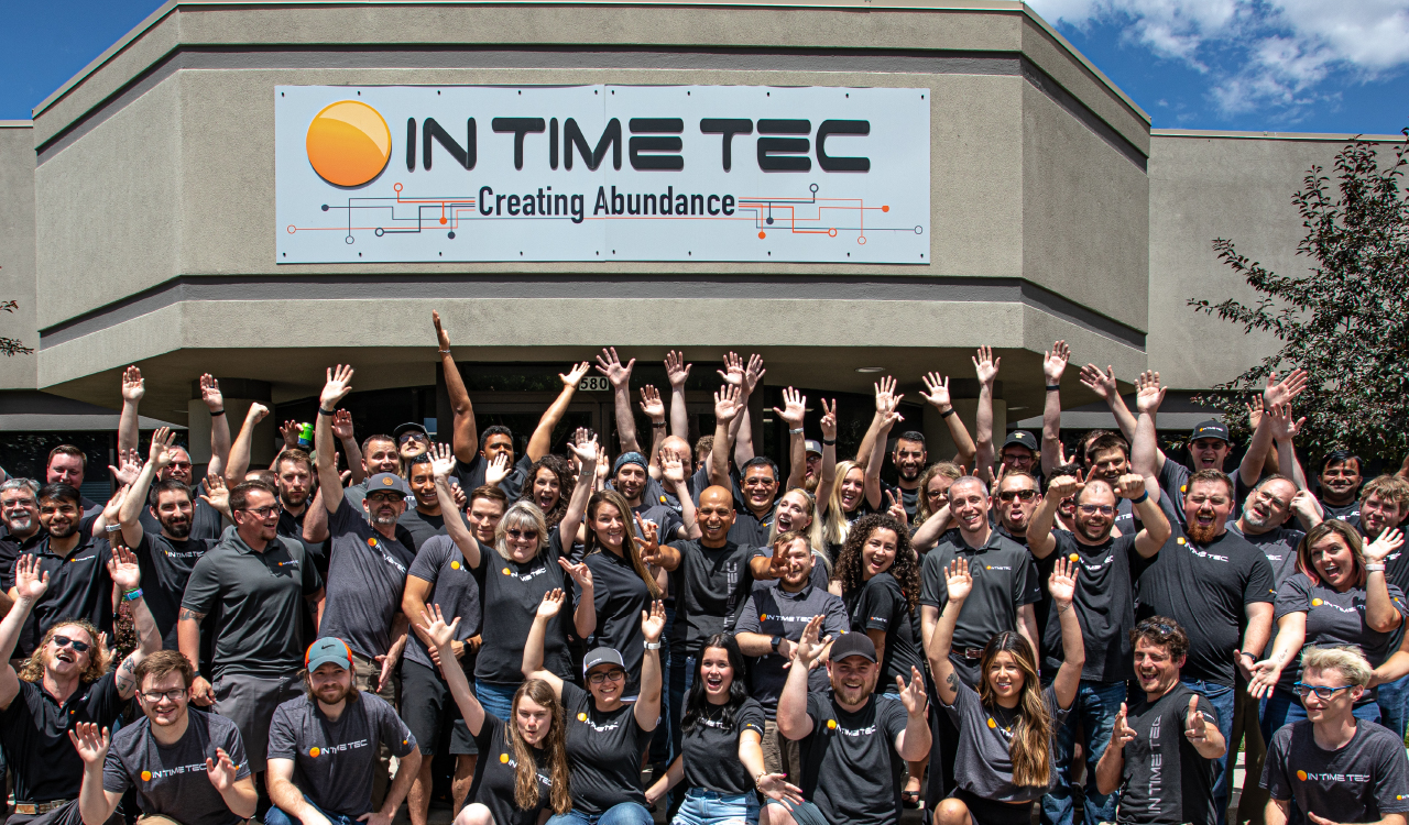 group of employees standing in front of In Time Tec office 